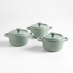 three green casserole dishes with lids on white background