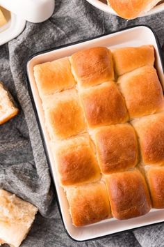 several square pieces of bread in a white dish on a gray blanket next to other dishes