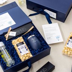 an open blue box with two bottles and some snacks in it next to other items