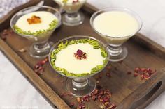 three desserts are sitting on a tray with flowers in the bowl and garnishes