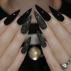 a woman's hands with black and silver nails