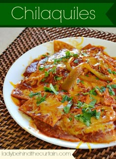 a white plate topped with lasagna covered in cheese and sauce on top of a woven place mat