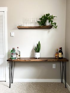 a table with some plants and bottles on it in front of a white door way