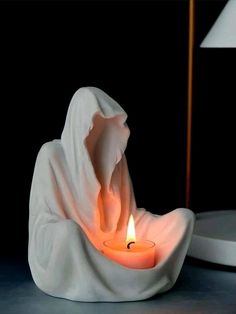 a candle that is sitting in the middle of some kind of white cloth on a table