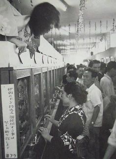 a group of people standing next to each other near vending machines