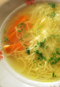 a white bowl filled with noodles and carrots