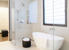 an image of a bathroom with white walls and tub in the corner walk in shower