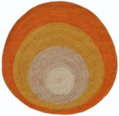 an orange and white rug on top of a wooden floor with circles in the center