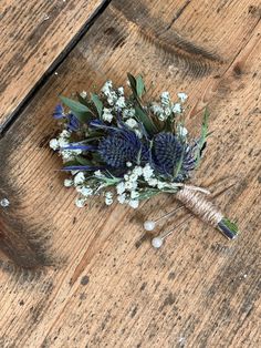 a bouquet of flowers sitting on top of a wooden floor next to a feather pen