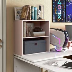 a desk with a computer, printer and other items on it in front of a painting