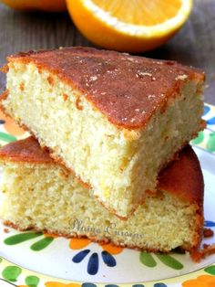 two pieces of cake sitting on top of a plate next to an orange and another piece of fruit