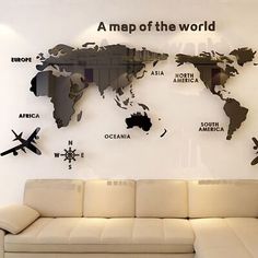 a couch sitting in front of a white wall with a world map on the wall