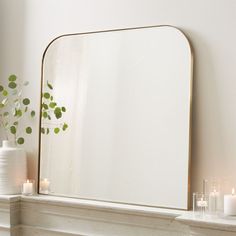 a mirror sitting on top of a mantle next to candles