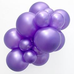 a bunch of purple balloons floating on top of each other in the air with white background