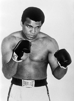 a black and white photo of a man wearing boxing gloves