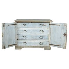 an old blue dresser with two doors open on the front and one door closed to reveal a drawer