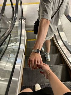 two people on an escalator reaching for something