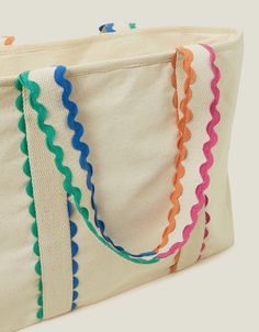 a large white bag with multicolored scalloped handles