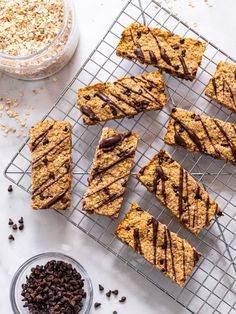 chocolate drizzled on top of oatmeal bars next to a bowl of granola