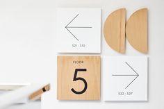 three wooden numbers are placed on the wall next to each other, and one number is 5