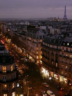 an aerial view of the eiffel tower in paris at night with cars parked on the street