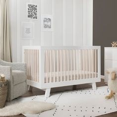 a baby's room with a white crib and sheep rug