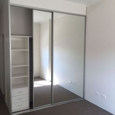 an empty room with white closets and open glass doors on the wall, in front of a window