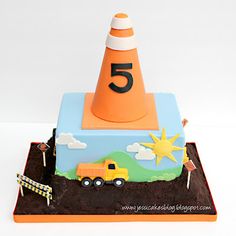 a birthday cake with a traffic cone and truck on it's top that says 5