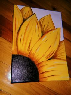 a painting of a sunflower on a wooden floor