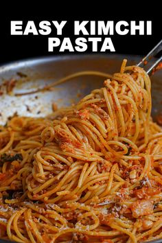 spaghetti being cooked in a skillet with the words easy kimchi pasta above it