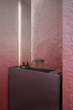 there is a sink and mirror in the bathroom with pink walls on both sides of it