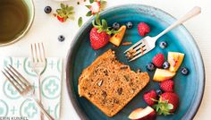 a blue plate topped with bread and fruit next to a cup of coffee on top of a table