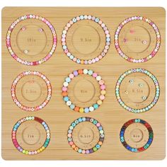 a wooden board with different colored bracelets and numbers on the front, along with two rows of beads in each circle