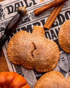 some cinnamon sugar cookies on top of a newspaper next to an apple and cinnamon stick