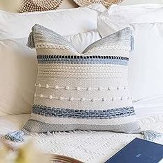 a white bed topped with pillows and a book