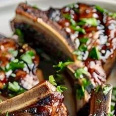 grilled steaks on a white plate topped with parsley