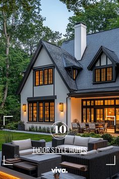 a large white house with lots of windows and furniture in front of the porch area