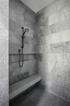 a walk in shower sitting inside of a bathroom next to a wall mounted faucet