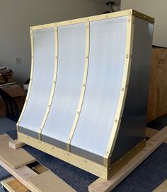 a large metal structure sitting on top of a blue floor next to plywood planks