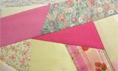 a close up of a patchwork quilt with pink, yellow and green colors on it