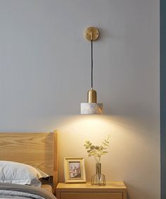 a bedroom with a bed, night stand and lamp on the side table next to it