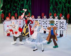 the children are dressed up as alice and the wonderland characters in front of an ice rink