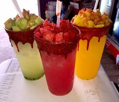 three drinks with strawberries, cucumbers and ice cream on a table in a restaurant