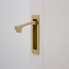 an open door with a brass handle on the front and side of it, in a white room