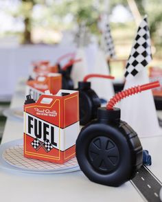 toy cars are lined up on the table at a race themed birthday party for kids