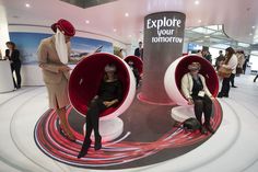 two people sitting in red chairs with their heads coverings