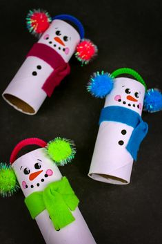 three snowmen made out of toilet paper tubes with pom - poms on them