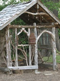 an old wooden structure with vines growing out of it and a rusty water faucet hanging from the roof