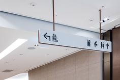 a white sign hanging from the side of a wall next to a doorway and ceiling