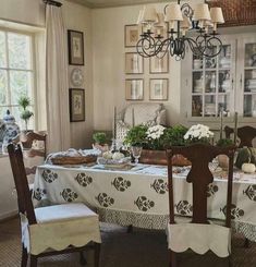 the dining room table is set with white flowers and place settings for two people to sit at